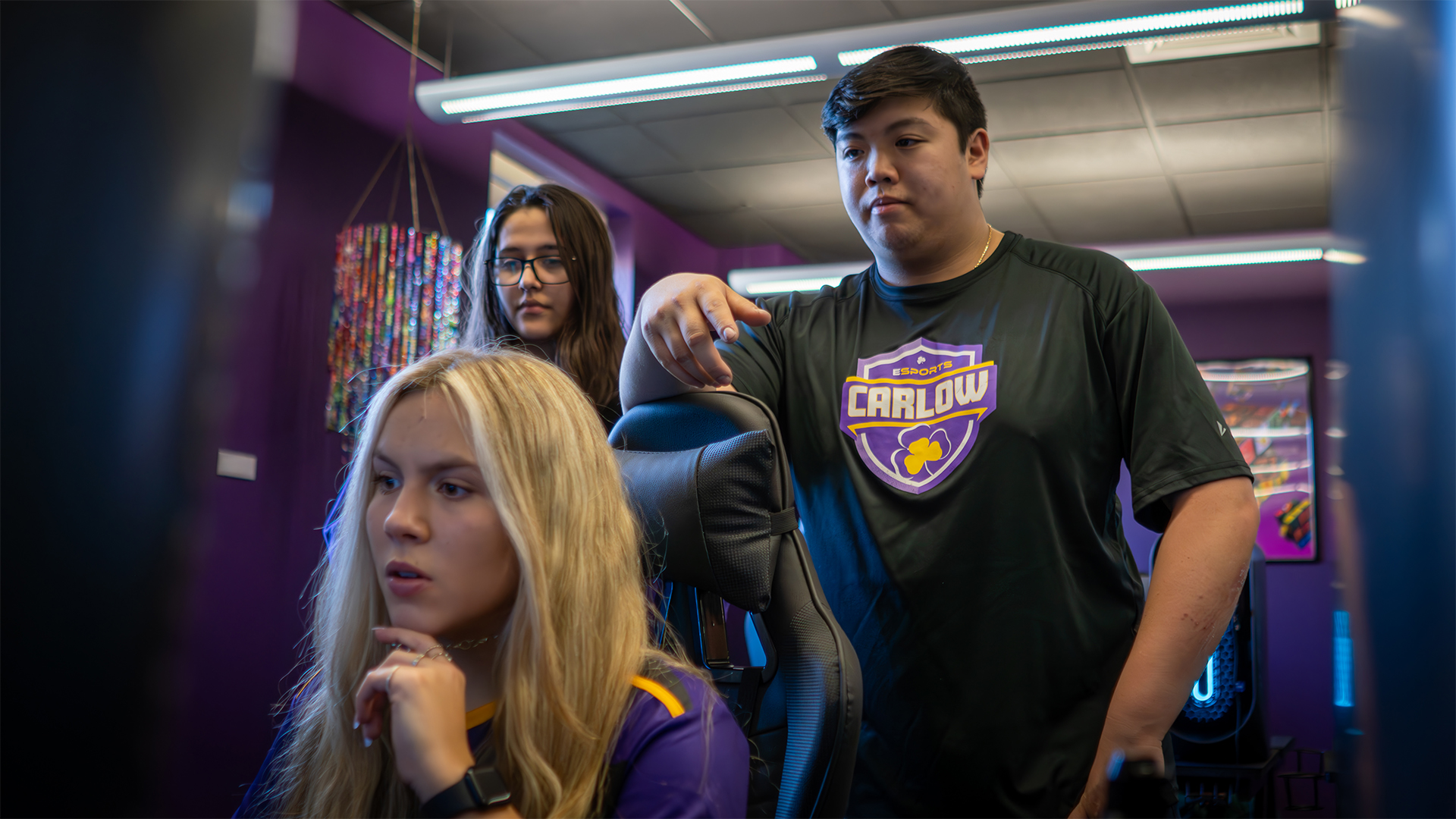 Lily Ibanez and AJ Nguyen watch over Alena Hemminger’s shoulder. Photo courtesy of Carlow University Marketing.